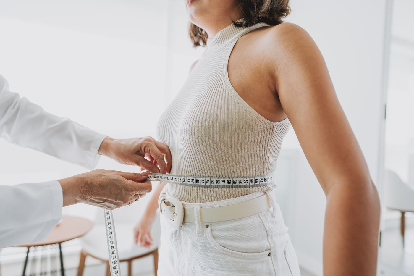 Clinician measuring a patient’s waist during a body-composition assessment